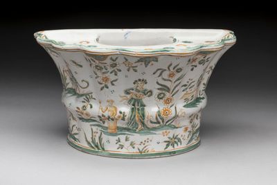 a white bowl with green and yellow designs on it