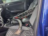 the interior of a car with the door open and a steering wheel in the passenger seat