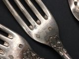 two forks and two spoons on a black table