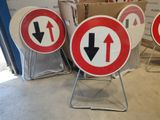 several red and white signs with arrows pointing in different directions