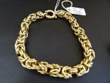 gros plan d'un bracelet en chaîne en or sur une table