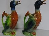 two ceramic ducks that are sitting on a table