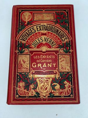 un vieux livre rouge avec des lettres dorées sur fond blanc