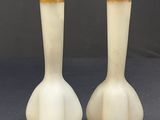 two white vases sitting on top of a table next to each other