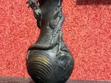 un vase noir orné d'un dragon, posé sur une table
