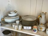 une étagère sur laquelle sont posés de nombreux plats et tasses