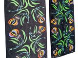 deux serviettes noires ornées de motifs floraux colorés, accrochées à un mur