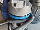 a vacuum that is sitting on the floor next to a bag