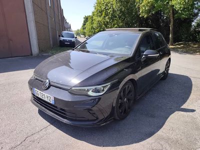 une Volkswagen Golf R-Line noire garée devant un immeuble
