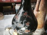 a black vase sitting on top of a table next to other vases