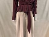 une photo d'un mannequin portant un haut bordeaux et un pantalon beige