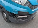 the front end of a blue van with a denting front bumper