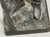 a statue of a man holding a baseball bat on a base