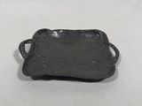 an antique cast iron tray with handles on a white background