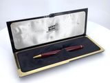 a red pen in a gold box on a white table