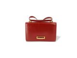 le petit sac rouge est posé sur une surface blanche