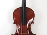 an old violin on a stand against a white wall