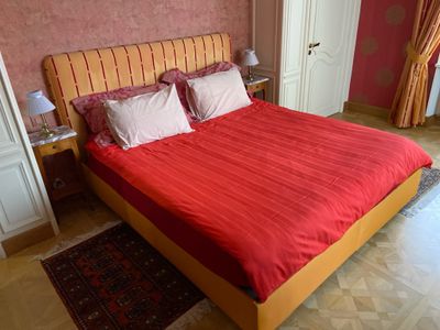 un lit avec des draps et des oreillers rouges dans une chambre à coucher