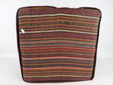an orange, brown and blue striped bag sitting on top of a white table