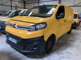 une camionnette jaune Citrole garée dans un entrepôt avec d'autres véhicules