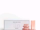 l'image d'un flacon de parfum posé à côté d'une boîte