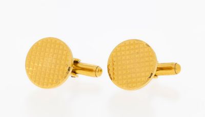 a close up of a pair of gold cufflinks on a white background