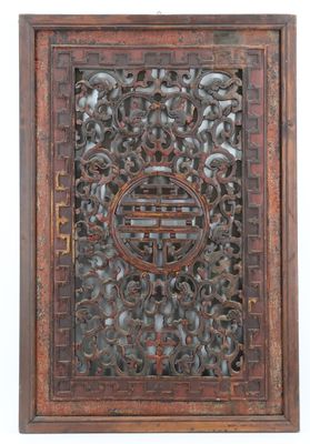 un ancien panneau en bois sculpté orné d'un motif circulaire