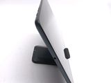 a tablet computer sitting on a stand on a white surface