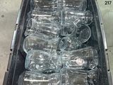 de nombreuses bouteilles vides dans un bac en plastique posé par terre