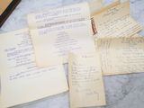 several papers are piled up on a table with a cup of coffee next to them
