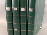 trois livres verts sont empilés les uns sur les autres sur une surface blanche