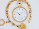 a gold pocket watch with a chain around it