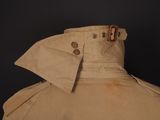 the back of a tan trench coat with buttons on it