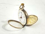 a pocket watch sitting on a table with a magnifying lens