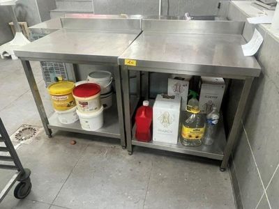 two stainless steel tables with buckets and containers on them