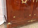 a wooden cabinet that has gold decorations on it