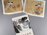 trois peintures chinoises représentant des oiseaux et des fleurs, posées sur une table