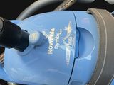 a blue vacuum that is sitting on a black surface