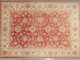 a red and beige rug with a floral design on it