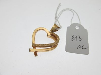 une bague en or ornée d'un cœur, à côté d'une étiquette de prix
