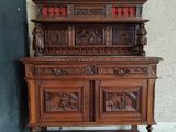 an old wooden cabinet with carvings on top of it next to a wall