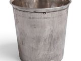 an old silver metal cup with a handle on a white background