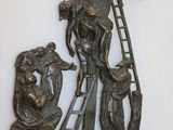 une sculpture métallique représentant un homme et une femme sur un pont