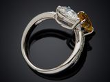 a close up of a ring with a yellow sapphire and a diamond