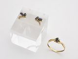 a close up of a ring and a pair of earrings on a white surface