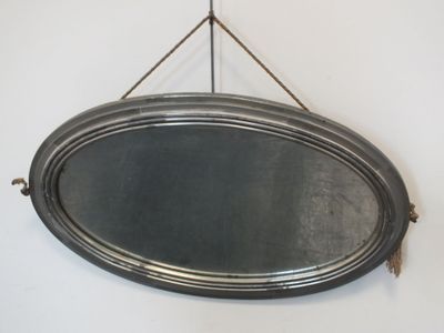 un miroir ovale argenté accroché au mur