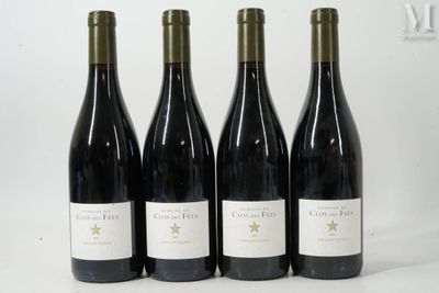 quatre bouteilles de vin rouge sont alignées sur une surface blanche
