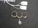 three rings and a necklace on a black surface