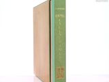 un livre vert posé sur une table blanche