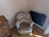 a chair in the corner of a room next to a dresser